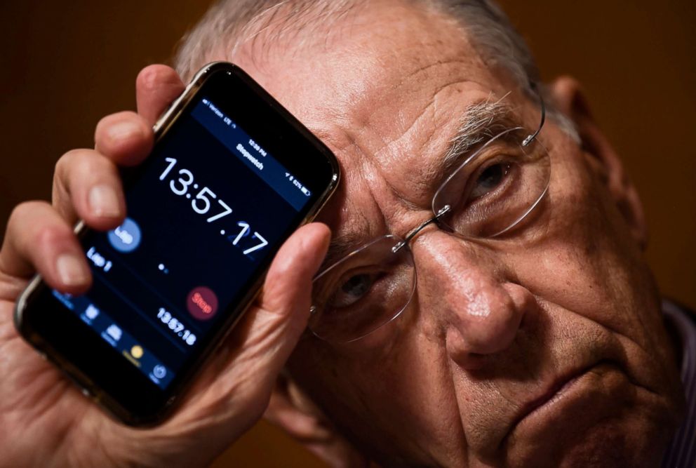 Senate Judiciary Committee Chairman Charles Grassley holds up his phone to show the time that Sen. Cory Booker has been speaking during a markup hearing on Capitol Hill in Washingto,n on Sept. 28, 2018, for the Supreme Court nomination of Brett Kavanaugh.