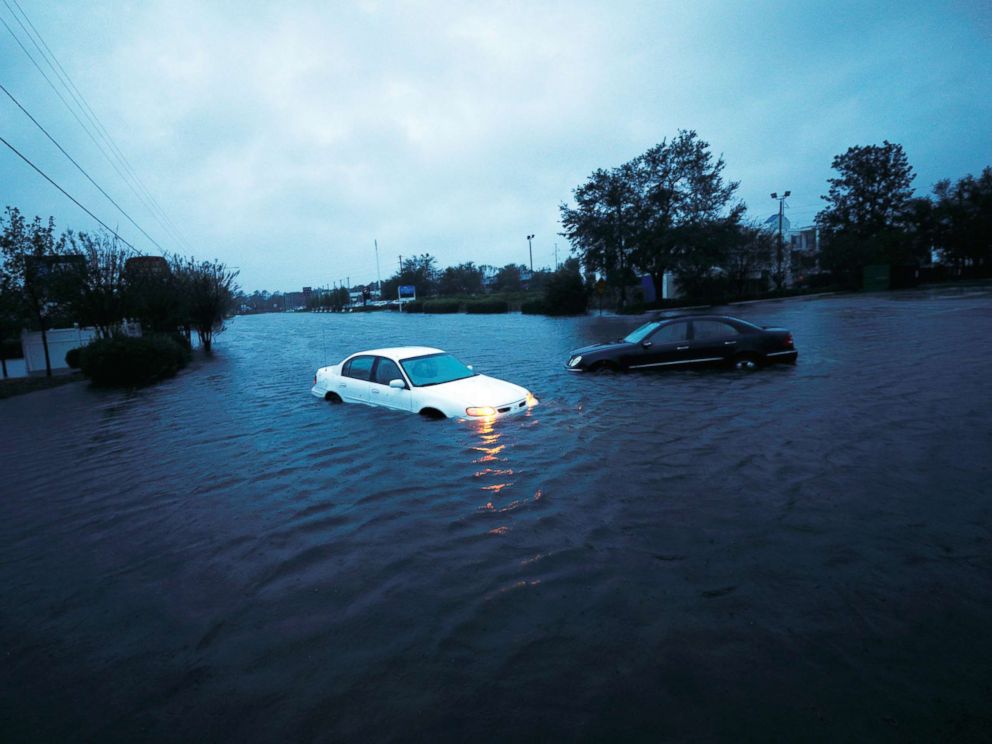 PHOTO: An abandoned cars hazard lights continue to flash as it sits submerged in rising flood waters during pre-dawn hours after Hurricane Florence struck in Wilmington, N.C., Sept. 15, 2018.