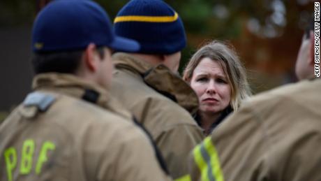 An unidentified woman asks for a status update from Pittsburgh City firefighters a block away from the site of the synagogue shooting.
