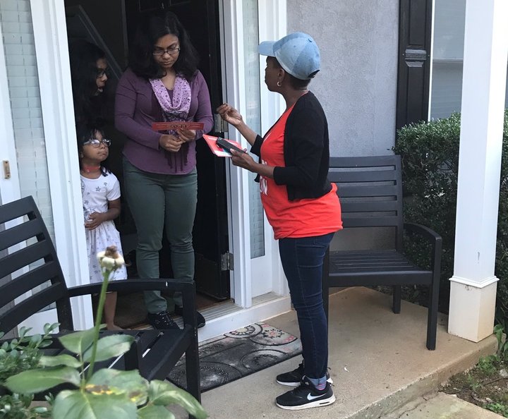 Nilaja Fabien, a 46-year-old nanny originally from Trinidad, talks to a woman in Gwinnett County, Georgia, about Stacey Abram