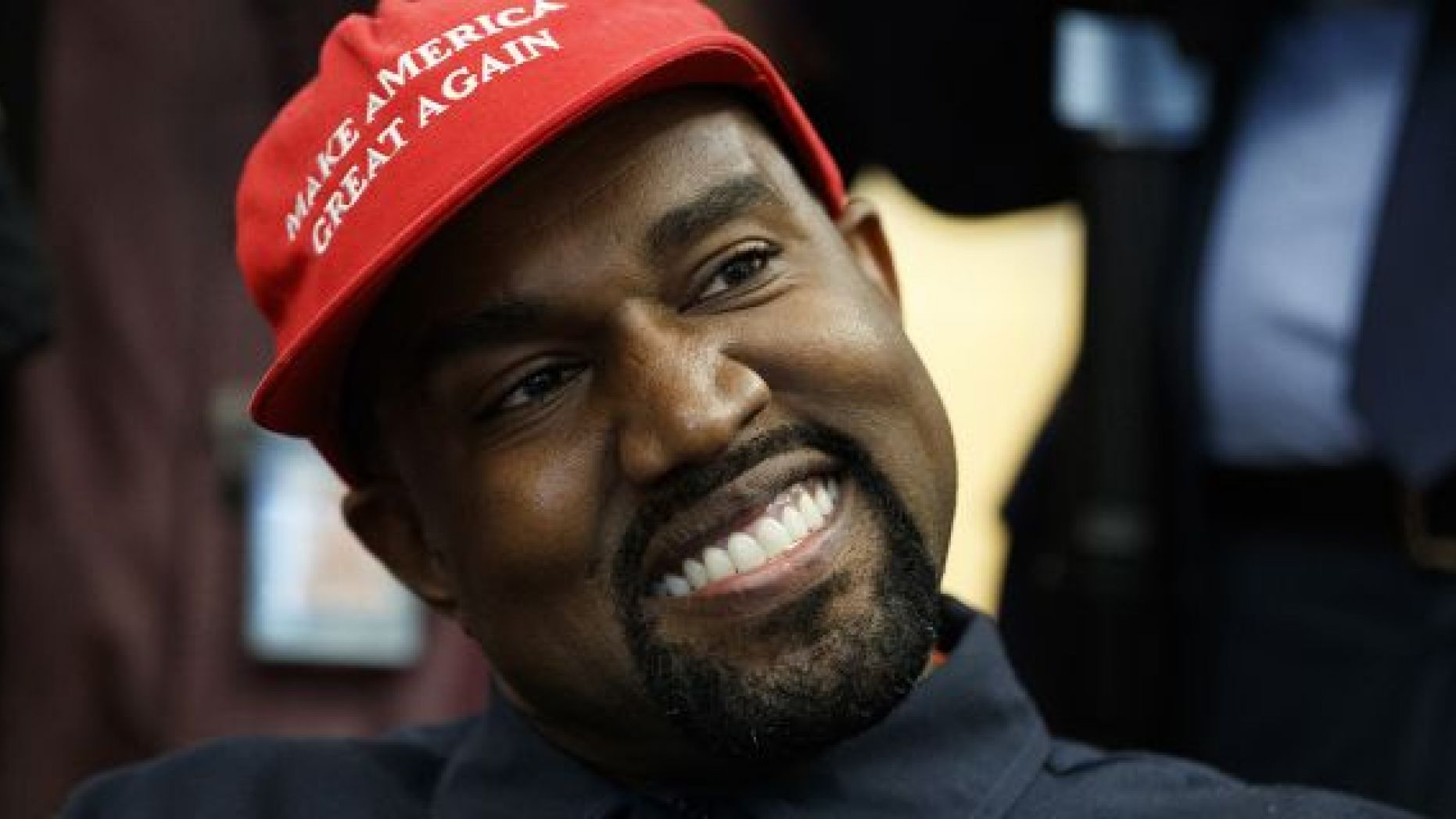Rapper Kanye West smiles as he listens to a question from a reporter during a meeting in the Oval Office of the White House with President Donald Trump.
