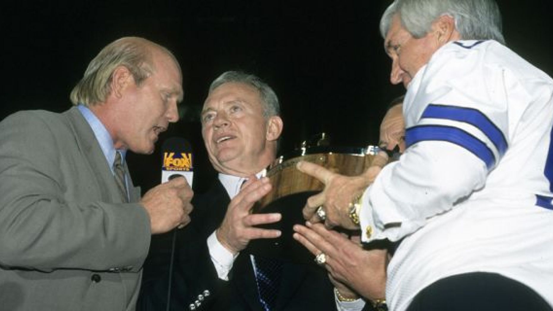 Terry Bradshaw talks to Dallas Cowboys owner Jerry Jones as former Cowboys great Lee Roy Jordan presents the George S. Halas Trophy following the NFC Championship Game, a 38-27 Cowboys victory over the Green Bay Packers in 1996. 