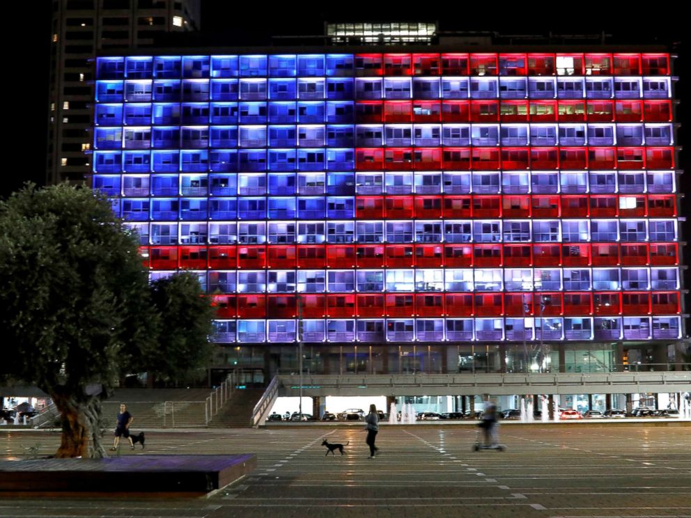 PHOTO: People walk by as the municipality building in Tel Aviv, Israel, is lit in the colors of the American flag in solidarity with the victims of the Pittsburgh synagogue attack, Oct. 27, 2018.