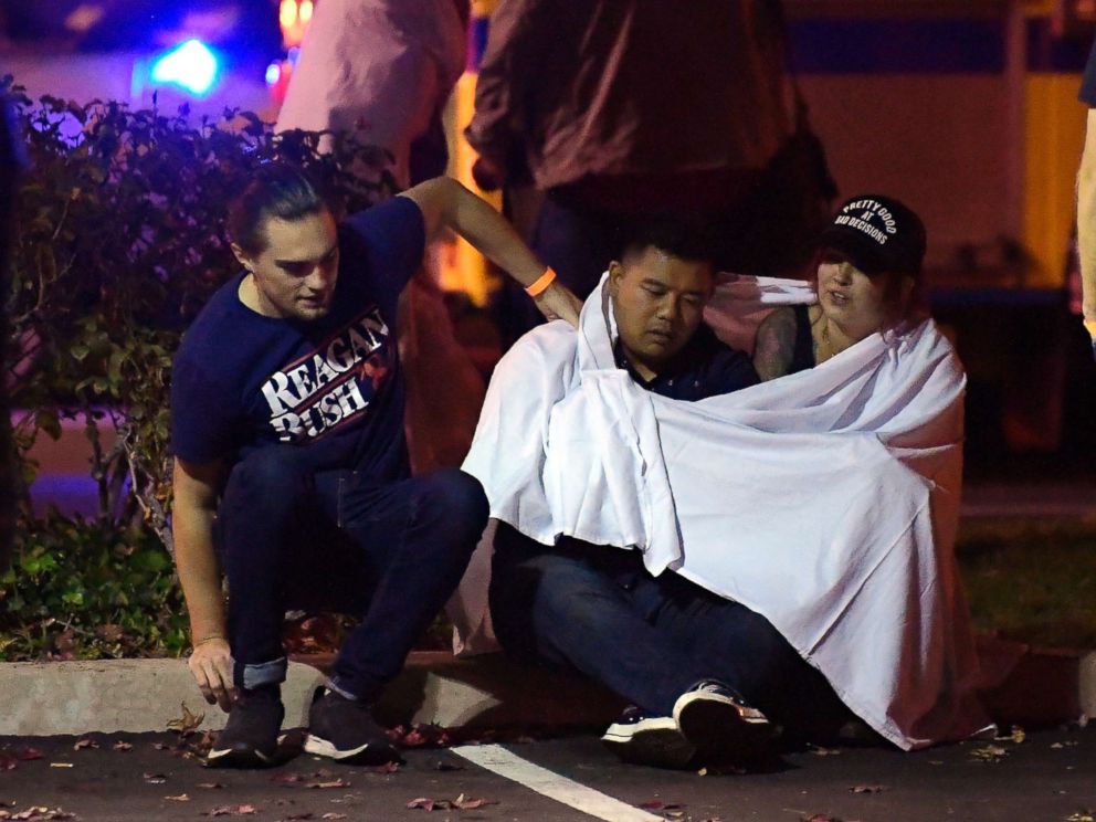 PHOTO: People comfort each other as they sit near the scene, Nov. 8, 2018, in Thousand Oaks, Calif. where a gunman opened fire Wednesday inside a country dance bar crowded with hundreds of people on college night.