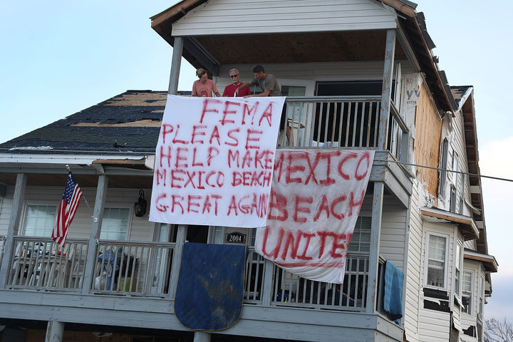 Residents hang a sign out that reads, 'FEMA Please Help Make Mexico Beach Great Again' outside their home that was damaged by
