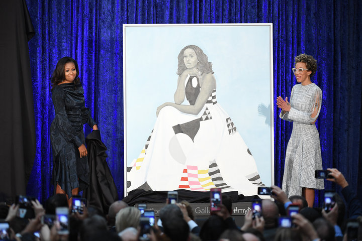 Former first lady Michelle Obama and artist Amy Sherald stand next to Obama's portrait as paintings of she and former Preside