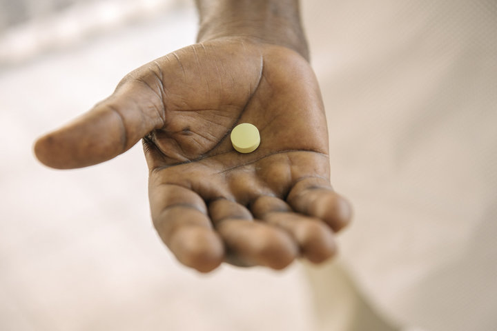 Dr. Victor Kande holds a single fexi pill. The drug is a dramatically simpler treatment for sleeping sickness.