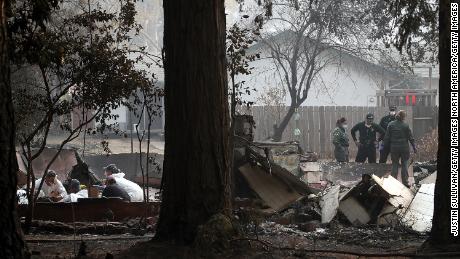  Sheriff deputies and rescue workers recover human remains from a home destroyed by the Camp Fire. 