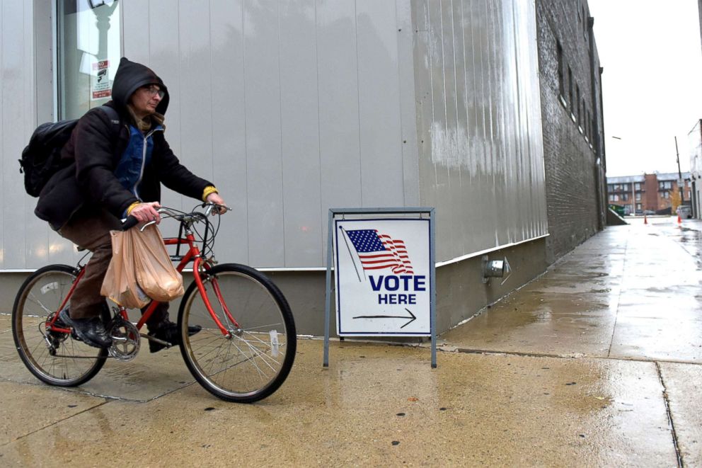 PHOTO: A cyclist passes by a sign directing voters to a polling station in Milwaukee, Nov. 4, 2018.