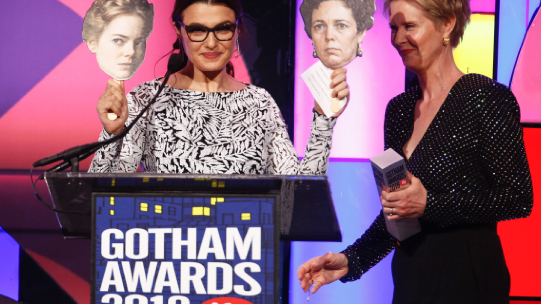Actress Rachel Weisz, left, holds photos of her co-stars Emma Stone and Olivia Colman from the movie "The Favorite" as she accepts a special honor from Cynthia Nixon, right, at the 28th annual Independent Filmmaker Project's Gotham Awards at Cipriani Wall Street on Monday, Nov. 26, 2018, in New York.