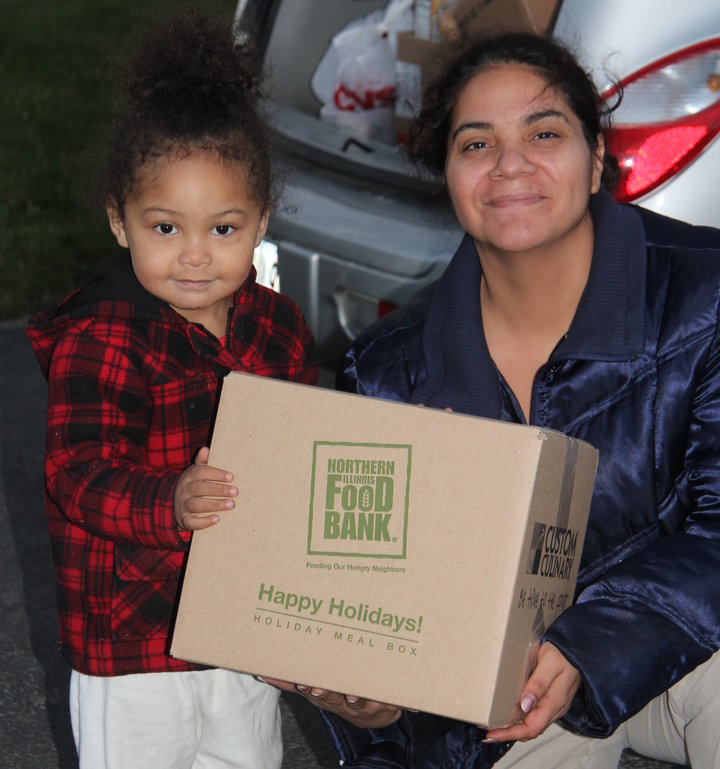 Veronica and her 2-year-old daughter receive a holiday meal box at Open Arms Mission Food Pantry in Antioch, Illinois, in 201