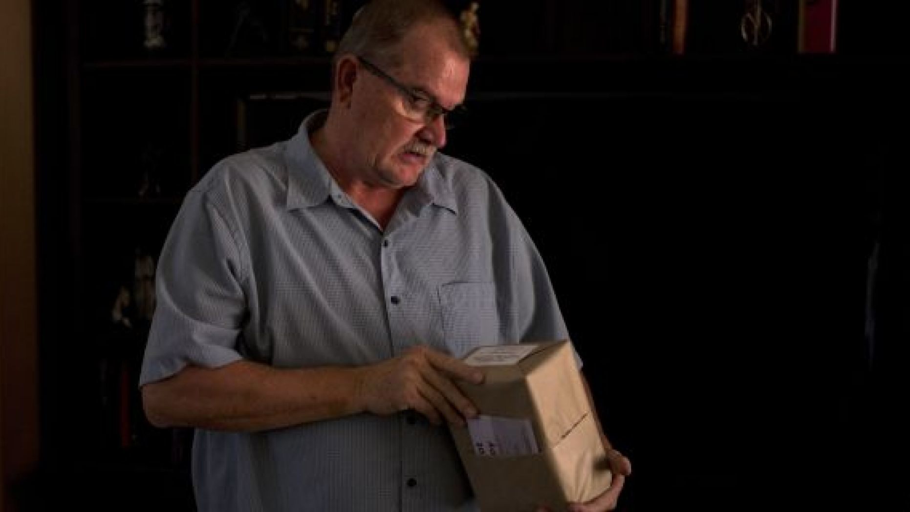 Doug Biggers, whose 20-year-old son, Landon, died of opioid overdose in 2017, looks at an unopened package containing the ashes of his son in La Quinta, Calif.