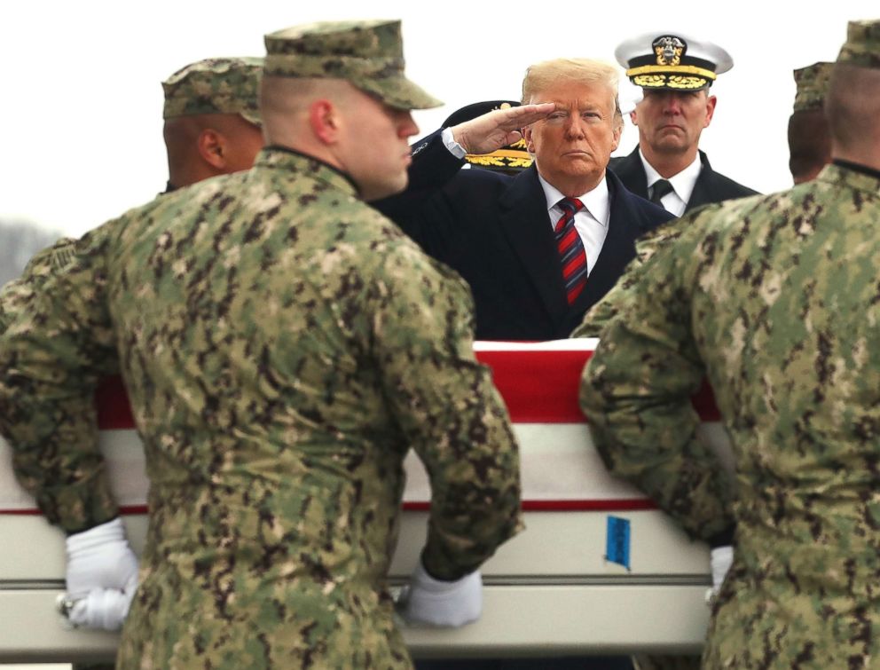 PHOTO: President Donald Trump salutes as a military carry team moves the transfer case containing the remains of Scott A. Wirtz during a dignified transfer at Dover Air Force Base, Jan. 19, 2019, in Dover, Del.