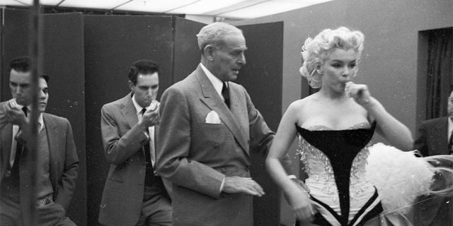 NEW YORK - MARCH 1955: Movie star Marilyn Monroe gets fitted for her costume in a dressing room before riding a pink elephant in Madison Square Garden for a circus charity event in March 1955 in New York City, New York.