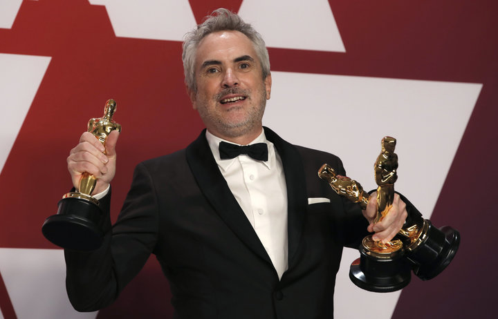 "Roma" director&nbsp;Alfonso Cuar&oacute;n poses with his three Oscars Sunday night.