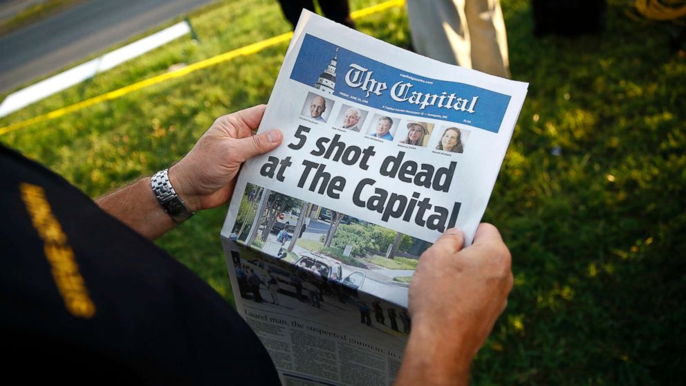 Steve Schuh, county executive of Anne Arundel County, holds a copy of The Capital Gazette near the scene of a shooting at the newspaper's office, June 29, 2018, in Annapolis, Md.