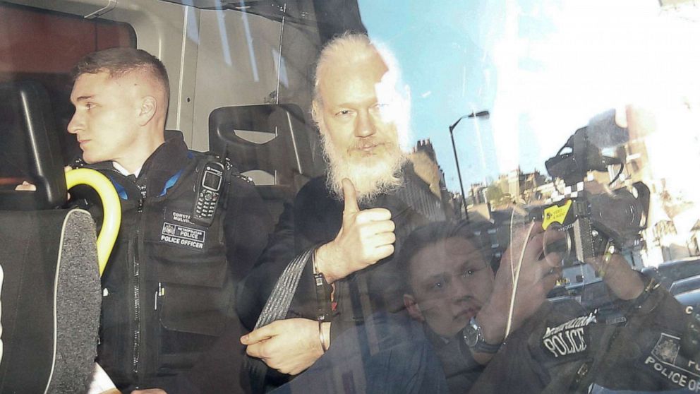 WikiLeaks founder Julian Assange gestures as he leaves the Westminster Magistrates Court in the police van, after he was arrested in London, April 11, 2019.