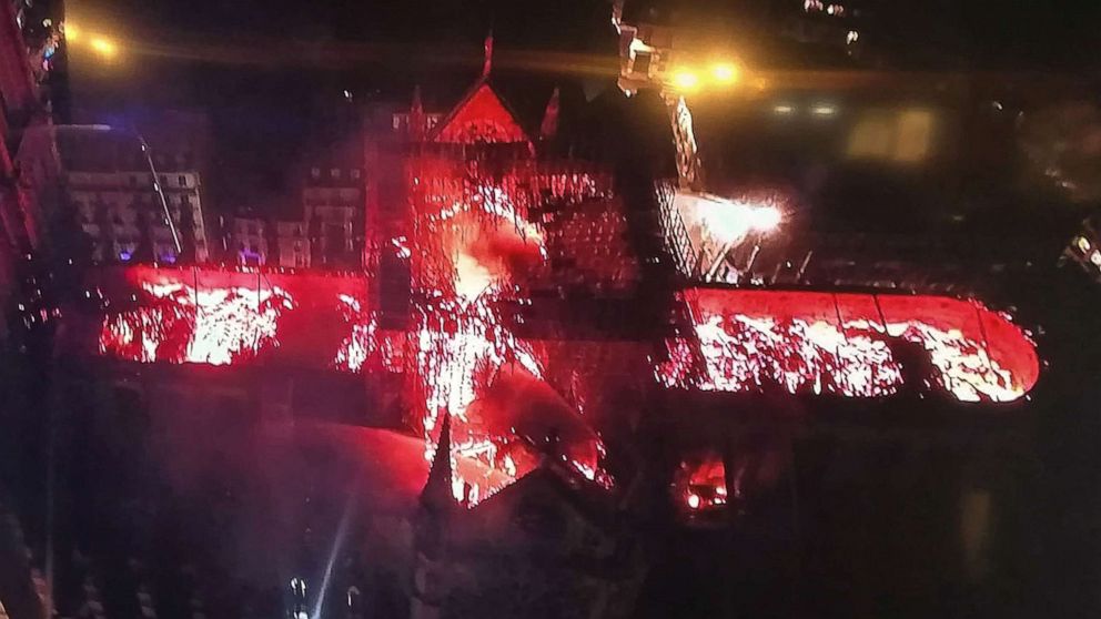 An image taken from a television screen shows an aerial view of the Notre-Dame Cathedral engulfed in flames on April 15, 2019, in the French capital Paris.