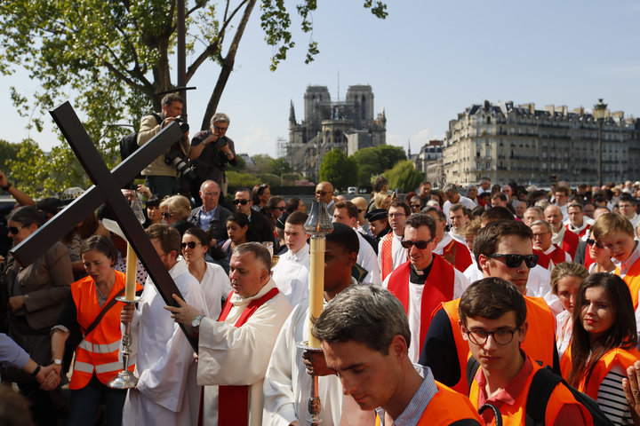 Religious officials carry the cross during a Good Friday procession in Paris on April 19, 2019.