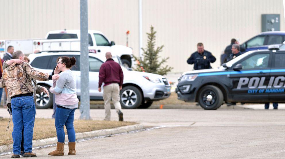 Family and friends console each other at the scene near the south side of the RJR Maintenance and Management building in Mandan, N.D., April 1, 2019.