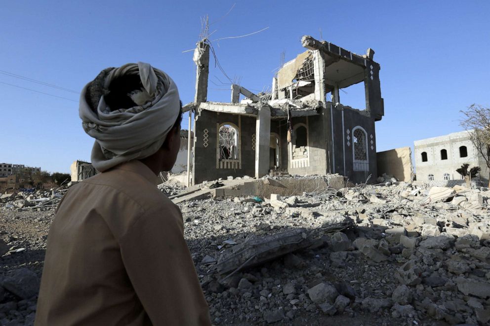 A Yemeni man sits in front of a building allegedly destroyed by recent airstrikes in Sana'a, Yemen, March 25, 2018.