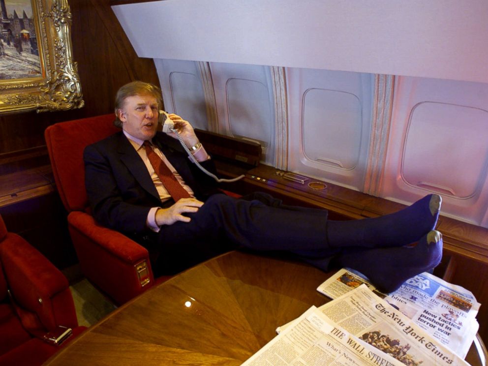 PHOTO: Donald Trump uses the phone and puts his sock-covered feet on the table in his private plane as he flies to Minnesota for a speech and to attend a fund-raiser for Gov. Jesse Ventura, Friday Jan. 7, 2000.