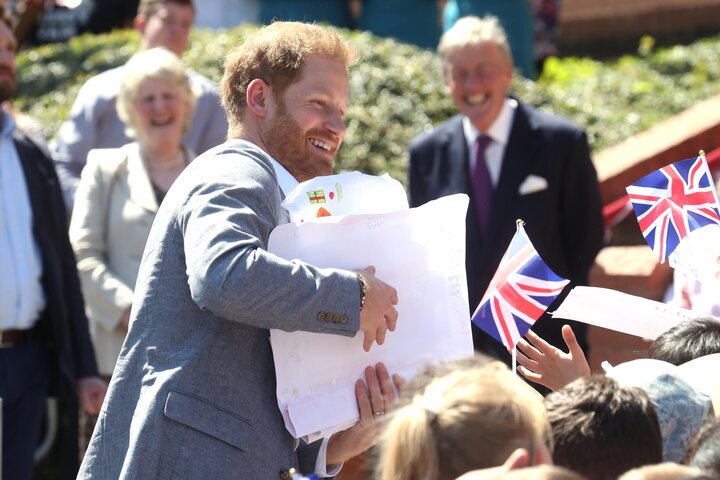 The Duke of Sussex receives gifts from well-wishers as he arrives for a visit to the Barton Neighbourhood Centre