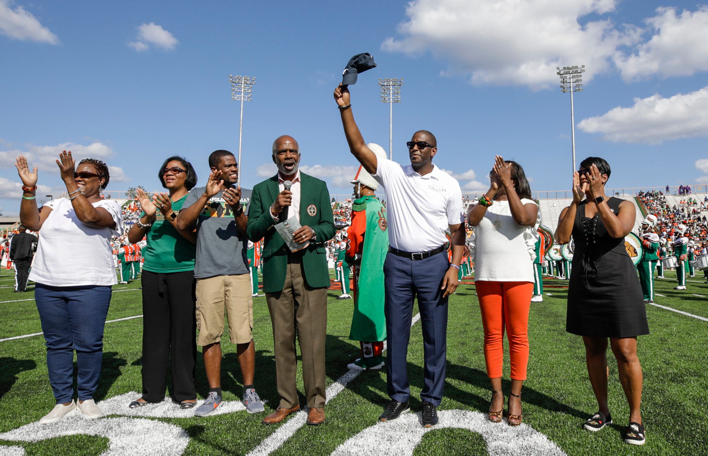 The Gillums stand with other FAMU alumni during the homecoming football game coin toss.