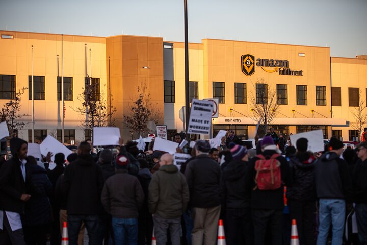 Demonstrators shout slogans and hold placards during a protest at the Amazon fulfillment center in Shakopee, Minnesota, Dec. 