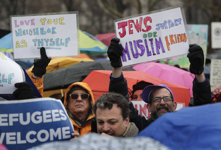 Demonstrators hold up signs during a rally in Battery Park organized by the Hebrew Immigrant Aid Society to mark a National D