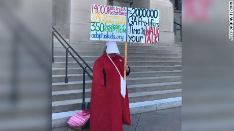 A woman dressed in a red cloak evoking &quot;The Handmaid&#39;s Tale&quot; protests outside Georgia&#39;s Capitol.