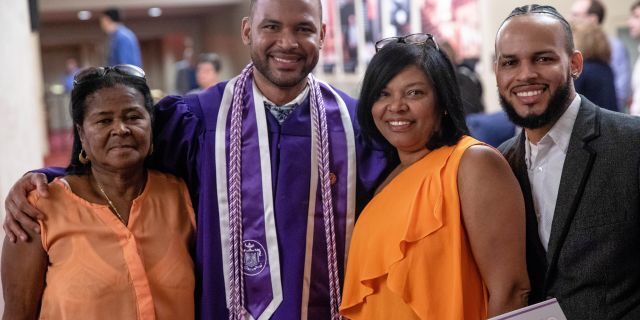 Frank Baez poses with family and friends after his graduation ceremony from the New York University Rory Meyers College of Nursing. 