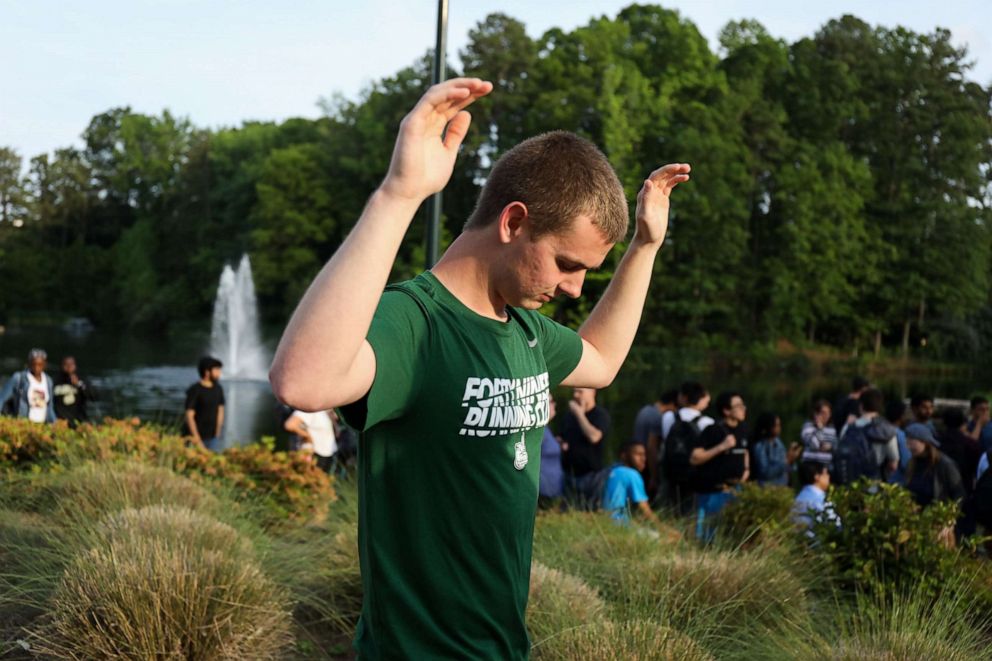 PHOTO: Students and faculty file out of buildings with their hands up during a lockdown after a shooting on the campus of University of North Carolina Charlotte in University City, Charlotte, on April 30, 2019.