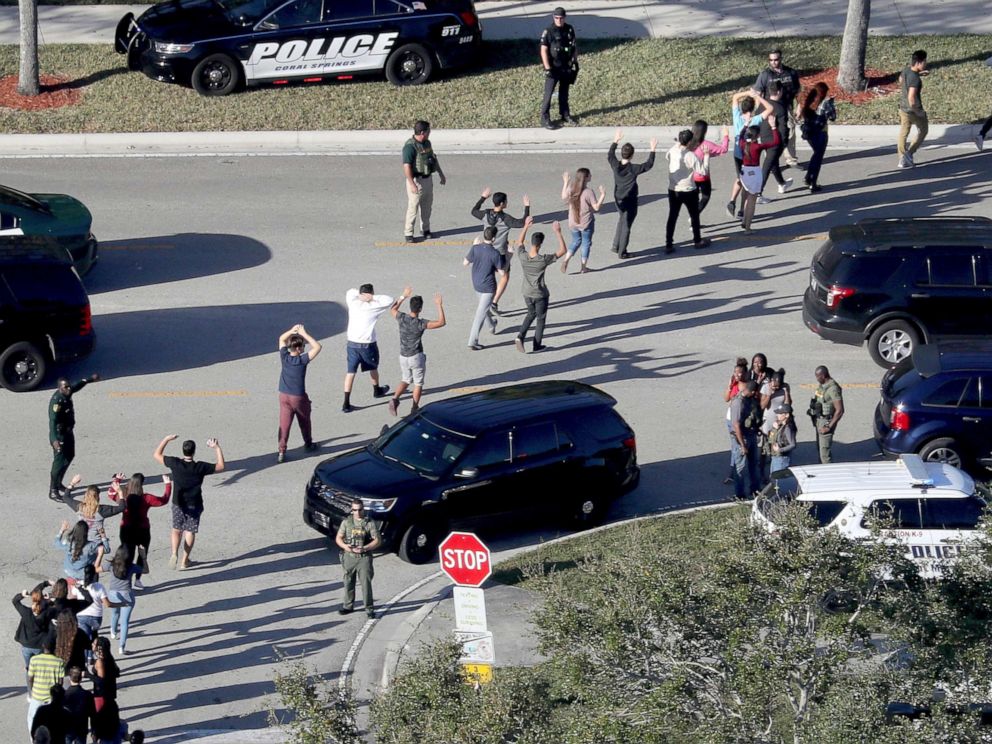 PHOTO: Students hold their hands in the air as they are evacuated by police from Marjory Stoneman Douglas High School in Parkland, Fla., after a shooter opened fire on the campus, Feb 14, 2018.