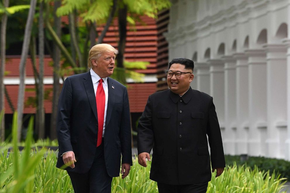 PHOTO: North Koreas leader Kim Jong Un, right, walks with President Donald Trump during a break in talks at their historic US-North Korea summit, at the Capella Hotel on Sentosa island in Singapore.