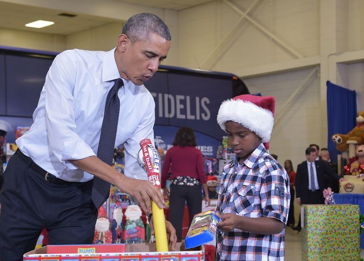 Obama and a young boy sort toys and gifts for the Marine Corps Toys for Tots campaign at Bolling Air Force Base in Washington, D.C., in December 2014.