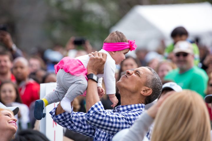 Obama plays with a baby at the 138th Annual Easter Egg Roll at the White House in March 2016.