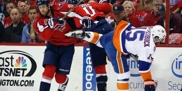 Washington Capitals center Brooks Laich (21), right wing Troy Brouwer (20) and New York Islanders right wing Cal Clutterbuck (15) collide during the first period of Game 5 in the first round of the NHL hockey Stanley Cup playoffs, Thursday, April 23, 2015, in Washington. (AP Photo/Alex Brandon)