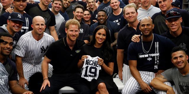 Britain's Prince Harry and Meghan, Duchess of Sussex pose for a picture with players of the New York Yankees.