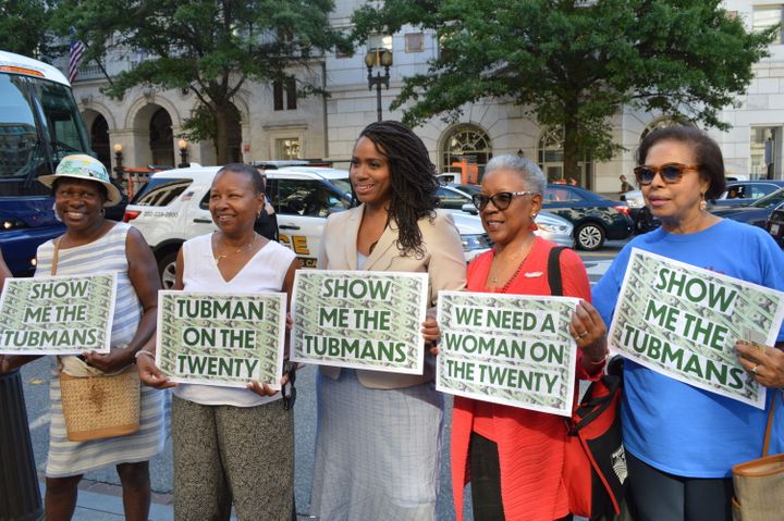 Rep. Ayanna Pressley (D-Mass.), center, holds up signs with supporters that call for Harriet Tubman to be put on the $20 bill
