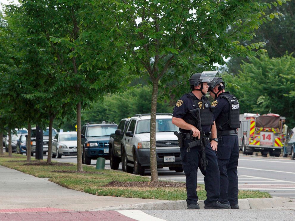 PHOTO: Virginia Beach Police Officers huddle near the intersection of Princess Anne Road and Nimmo Parkway following a shooting at the Virginia Beach Municipal Center, May 31, 2019, in Virginia Beach, Va.