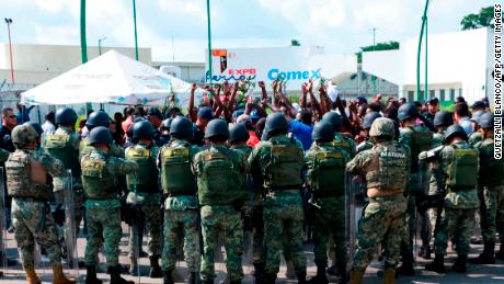 Military officers surround migrants protesting outside a shelter in Tapachula, Mexico, on June 18.
