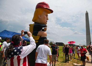 PHOTO: People take photos of a statue of President Donald Trump tweeting on a toilet, at the National Mall ahead of the, Salute to America Fourth of July event in Washington, July 4, 2019.