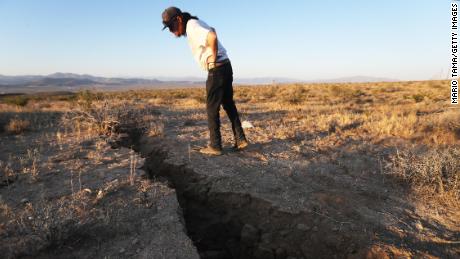 A man inspects a crack in the earth after a 6.4-magnitude earthquake struck near Ridgecrest on July 4, 2019.