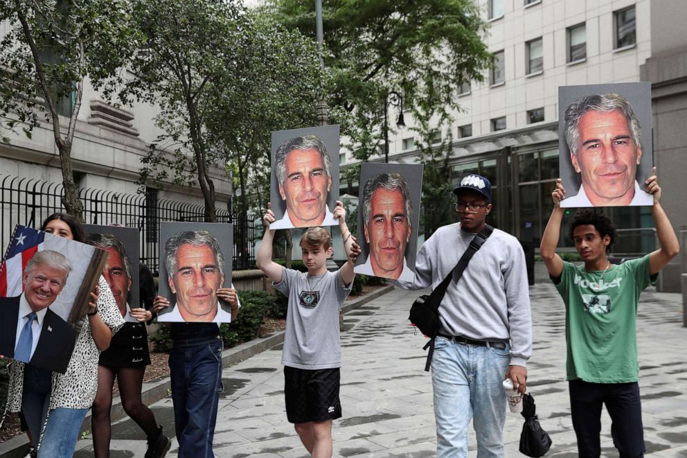 PHOTO: Demonstrators hold signs protesting Jeffrey Epstein, as he awaits arraignment in New York, July 8, 2019.
