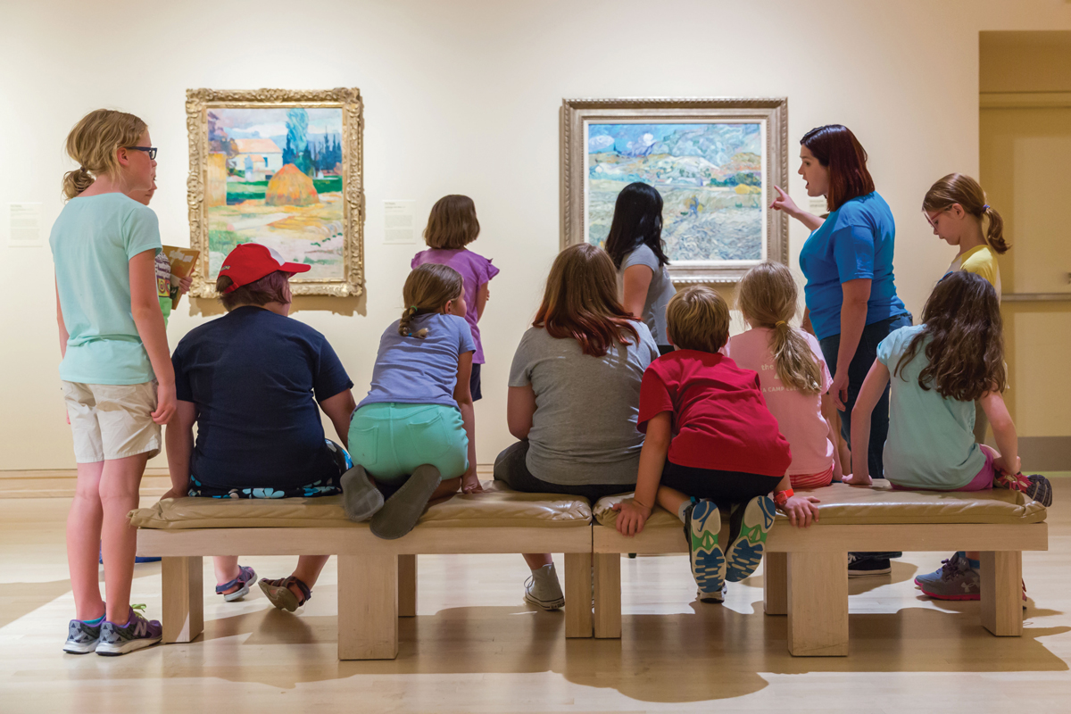 A museum tour group viewing works by Paul Gauguin and Vincent van Gogh.