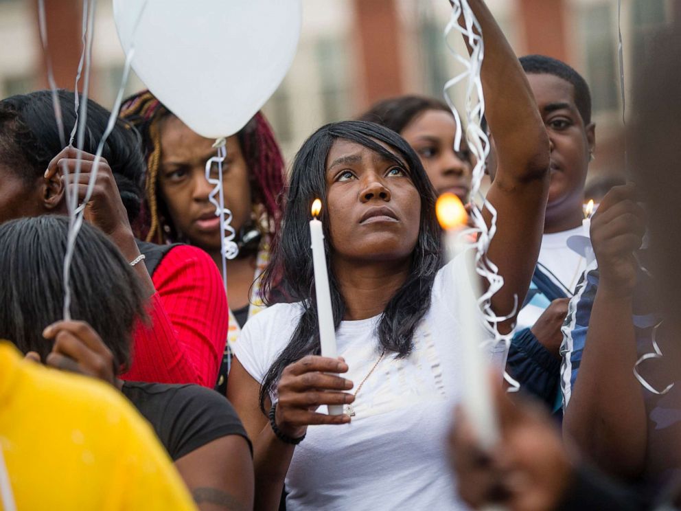 PHOTO: Sherika Logan looks up during a vigil for Eric Logan Monday, June 17, 2019 on Washington Street in South Bend, Ind.