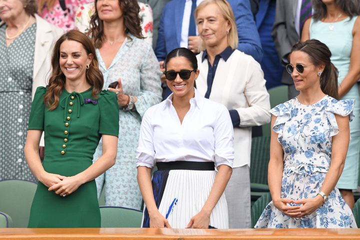 Retired tennis star Martina Navratilova stands behind the trio in the Royal Box.