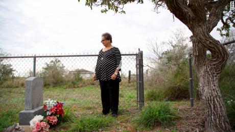 Melba Coody stands at the graves of Bazán and Longoria in Texas&#39; Rio Grande Valley.