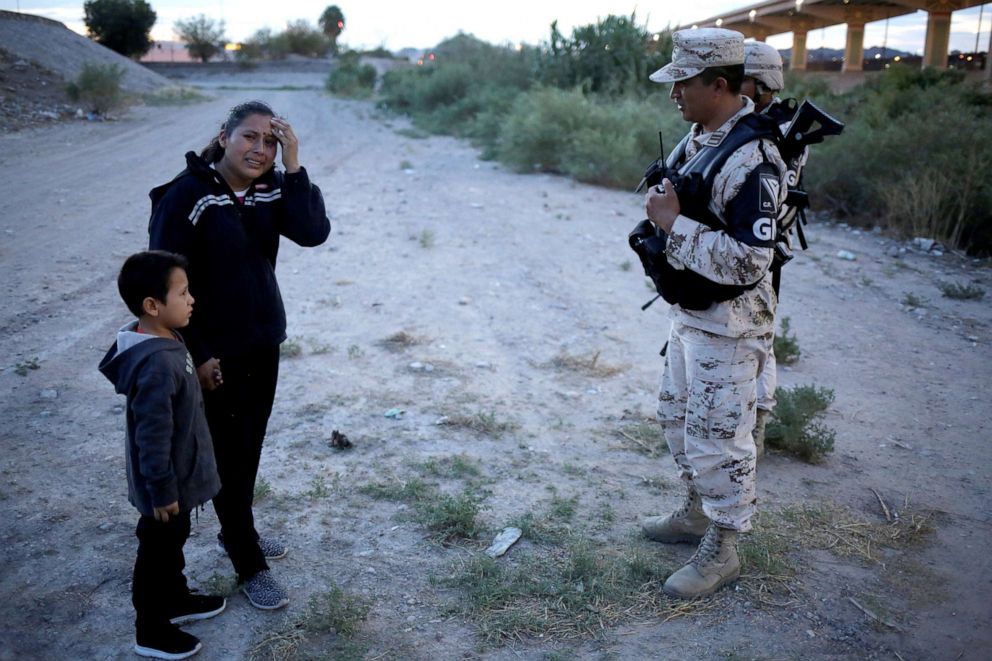 PHOTO: Guatemalan migrant Lety Perez reacts while holding hands with her son Anthony while asking members of the Mexican National Guard to let them cross into the United States, as seen from Ciudad Juarez, Mexico, July 22, 2019. 